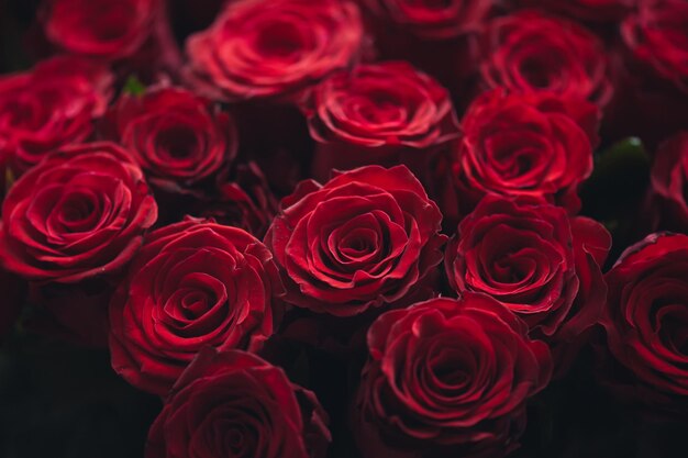 Un bouquet de roses rouges avec le mot amour en bas à gauche.