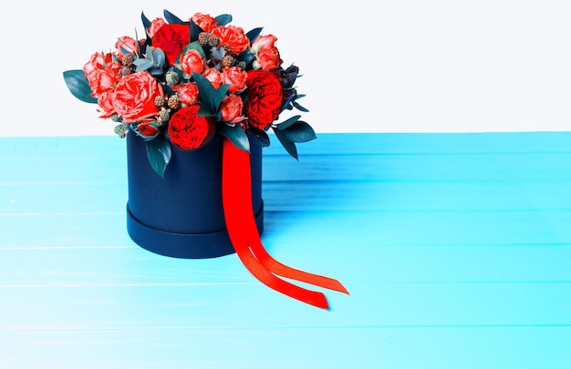 Bouquet de roses rouges et ruban rouge dans une boîte noire circulaire. Concept de la Saint-Valentin et anniversaire