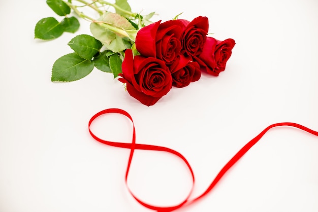 Bouquet de roses rouges avec un ruban rouge.