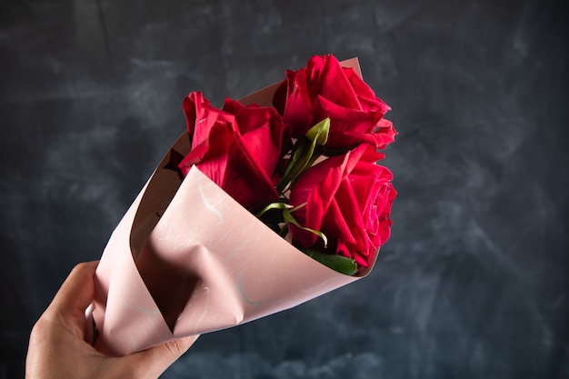 Photo bouquet de roses rouges sur une surface sombre