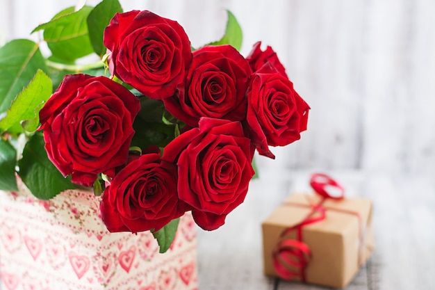 Bouquet de roses rouges sur une table en bois.