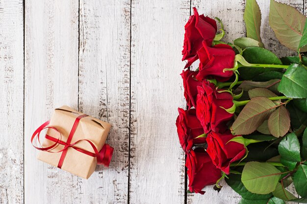 Bouquet de roses rouges sur une table en bois.