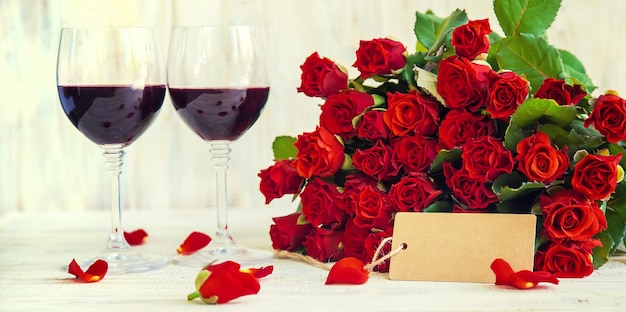 Un bouquet de roses rouges et de vin rouge dans des verres. La Saint-Valentin. Mise au point sélective. Vacances.