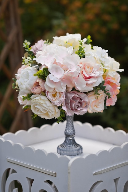 Un bouquet de roses sur un support comme décoration du territoire du mariage 32