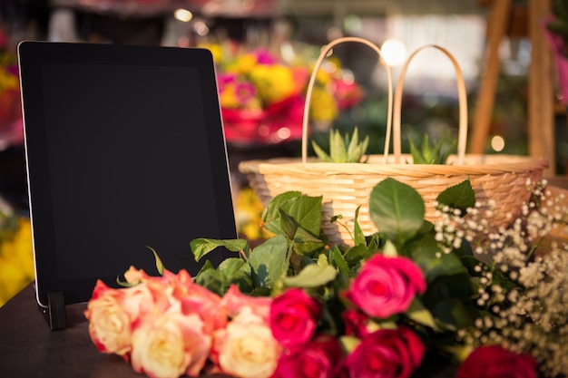 Bouquet de roses et tablette numérique sur la table