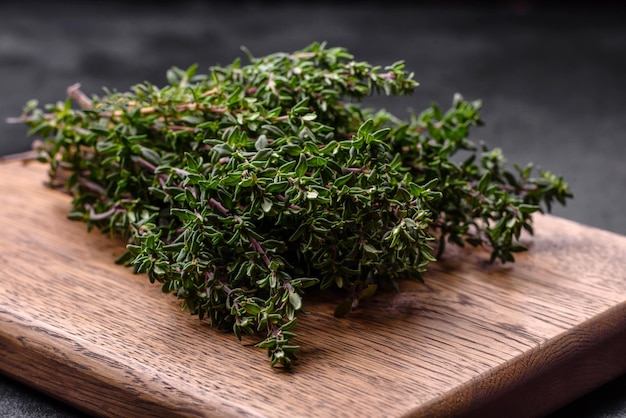 Bouquet de thym frais cueilli sur un fond de béton foncé Épices et herbes pour la cuisson de la viande