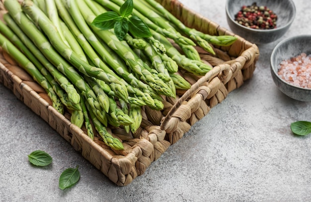 Un bouquet de tiges d'asperges crues avec différentes épices