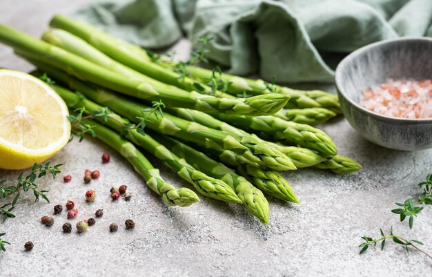 Bouquet de tiges d'asperges crues avec différentes épices