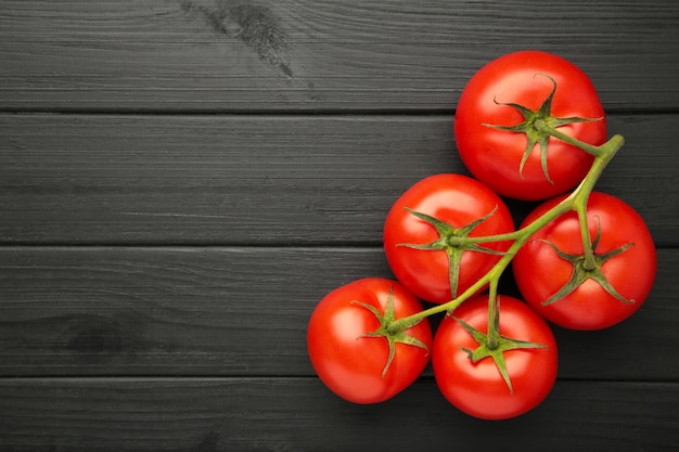 Bouquet de tomates fraîches sur fond noir La récolte des tomates Espace pour le texte