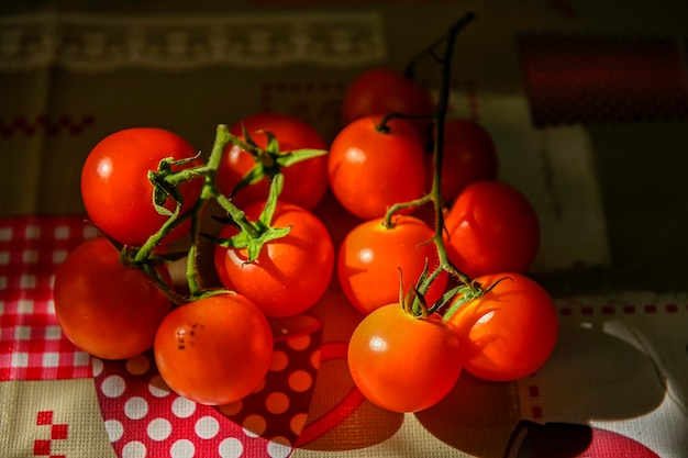 Bouquet de tomates rouges fraîches avec des tiges vertes sur la table de la cuisine