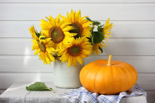 Bouquet de tournesols et d'une citrouille sur la table.