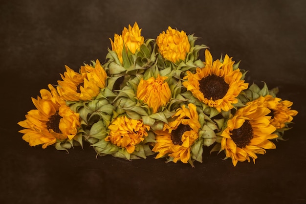 bouquet de tournesols jaunes se trouve sur une table sombre