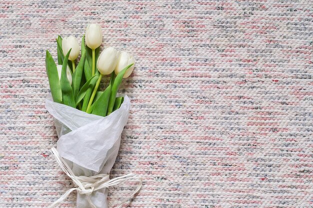 Bouquet de tulipes blanches sur fond textile rustique