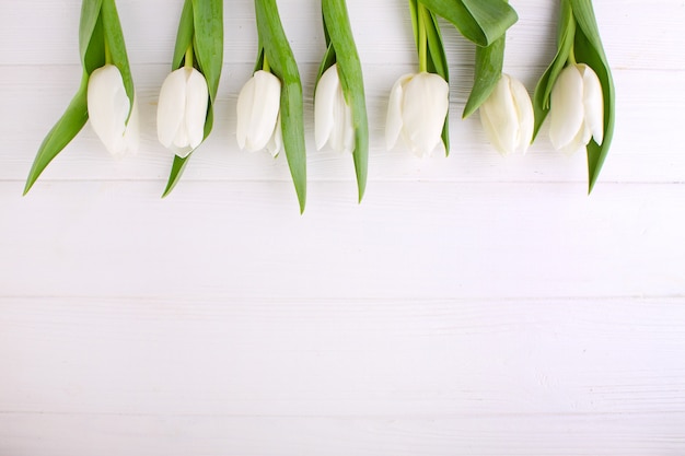 Bouquet de tulipes blanches sur une table en bois blanche, espace de copie. Pâques.