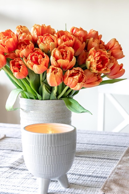 Un bouquet de tulipes et une bougie sur la table se bouchent