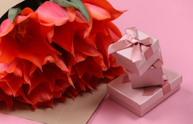 Bouquet de tulipes et coffrets cadeaux sur fond rose. Fête des mères ou 8 mars, anniversaire.