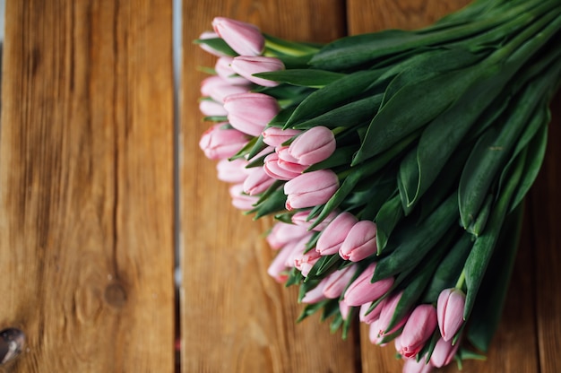 Bouquet de tulipes sur la conception de bordure de table en bois