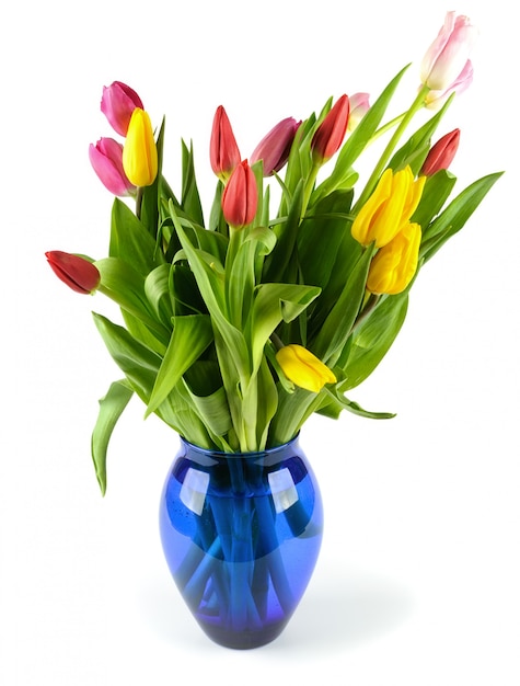 Bouquet de tulipes dans un vase en verre bleu.