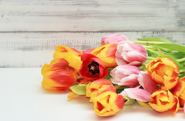 Bouquet de tulipes sur un fond en bois blanc.