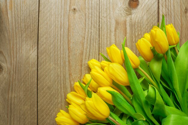 Bouquet de tulipes jaunes bloomig sur fond de bois. Place pour le texte, l'image noned