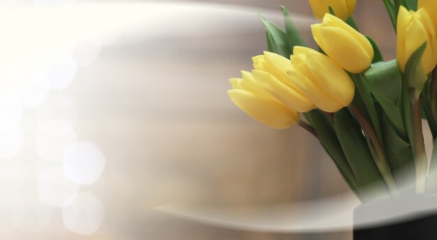 Bouquet de tulipes jaunes dans un vase au sol