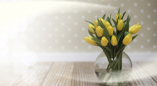 Bouquet de tulipes jaunes dans un vase au sol