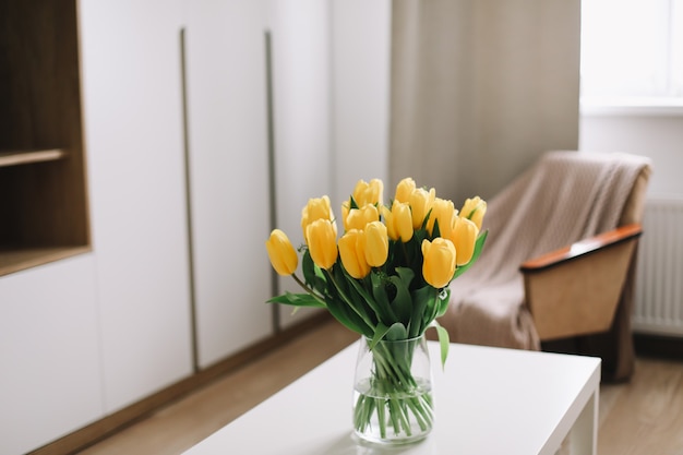 bouquet de tulipes jaunes fraîches sur une table à l'intérieur du salon