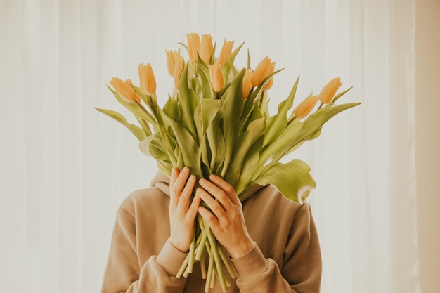 Un bouquet de tulipes jaunes à la main