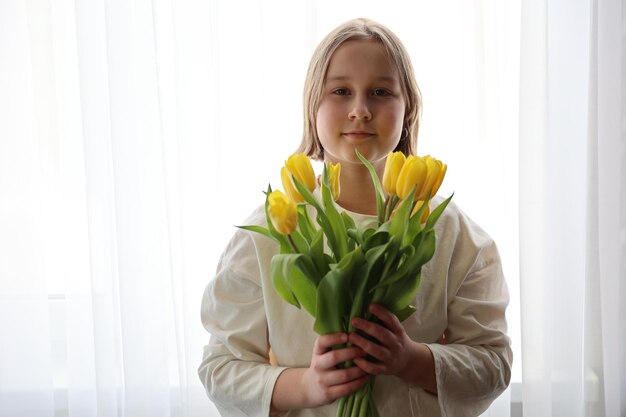 Un bouquet de tulipes jaunes à la main