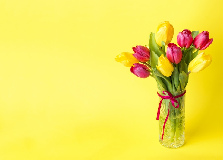 Photo bouquet de tulipes jaunes et roses sur fond jaune. espace de copie