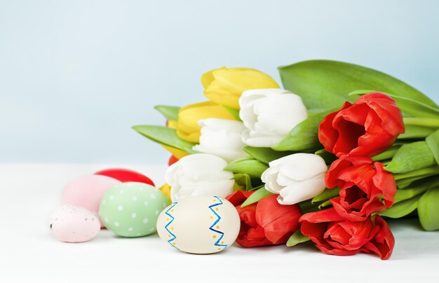 Bouquet de tulipes et d'oeufs de pâques sur fond clair