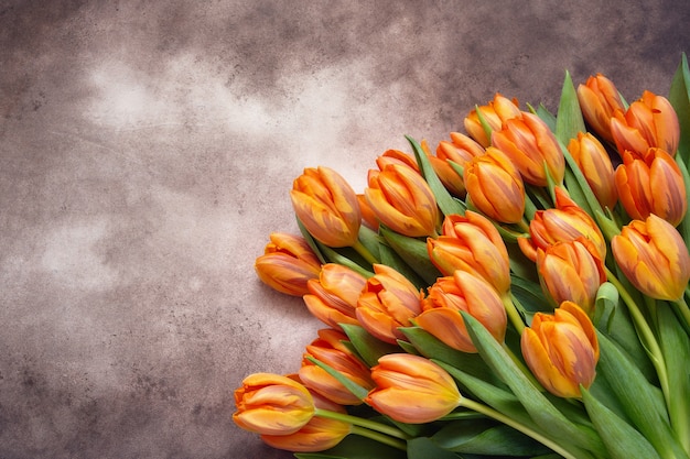 Bouquet de tulipes orange sur fond aquarelle marron copie espace vue de dessus vacances fond salutation