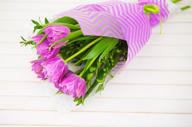 Bouquet de tulipes pourpres sur table en bois avec espace copie