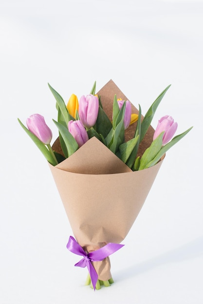 Un bouquet de tulipes de printemps dans la neige Carte de vœux pour la fête internationale de la femme le 8 mars