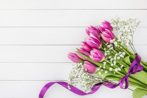 Bouquet de tulipes roses sur fond en bois blanc. Copiez l'espace, vue de dessus. Fond de vacances