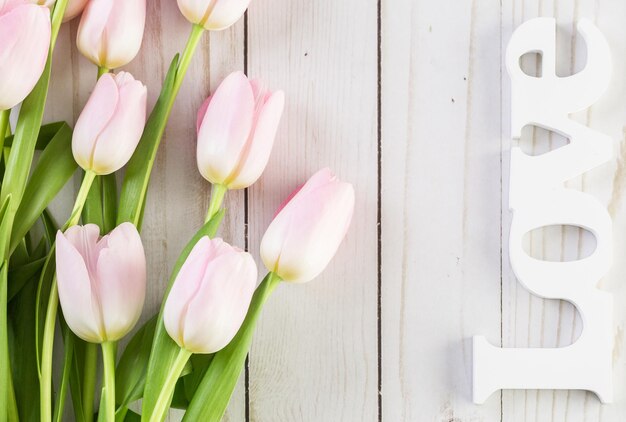 Bouquet de tulipes roses sur fond de bois.