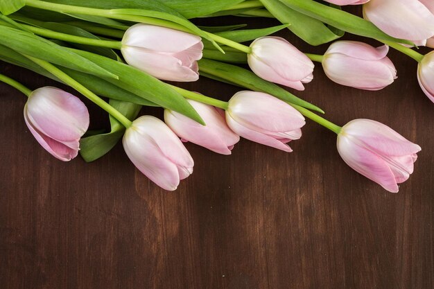 Bouquet de tulipes roses sur fond de bois.