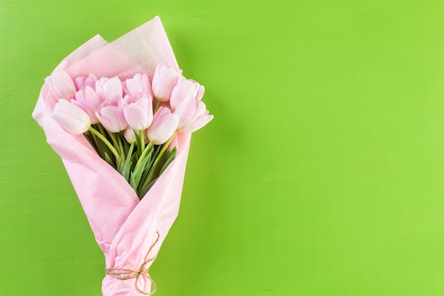 Bouquet de tulipes roses sur fond vert.