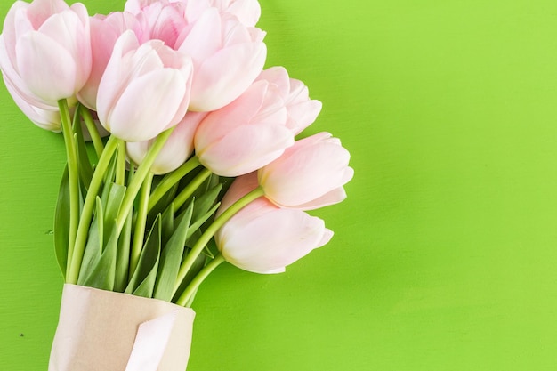 Bouquet de tulipes roses sur fond vert.