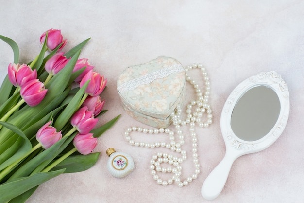 Bouquet de tulipes roses, miroir, flacon de parfum, coffret et perles de nacre