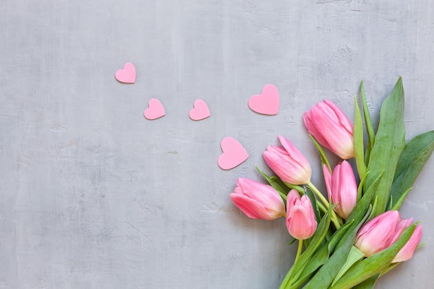 Bouquet de tulipes roses et motif de coeurs en bois