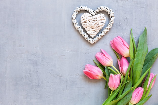 Bouquet de tulipes roses et motif de coeurs en bois