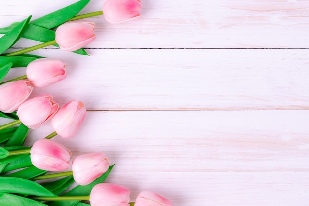 Bouquet de tulipes roses sur une surface en bois blanche