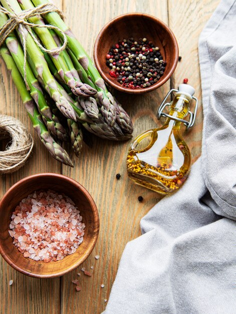 Bouquets d'asperges vertes et d'épices sur table en bois