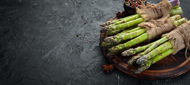 Photo bouquets d'asperges vertes fraîches sur fond noir alimentation saine vue de dessus espace libre pour votre texte