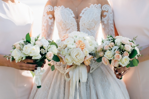 Bouquets de mariage entre les mains de la mariée et des demoiselles d'honneur