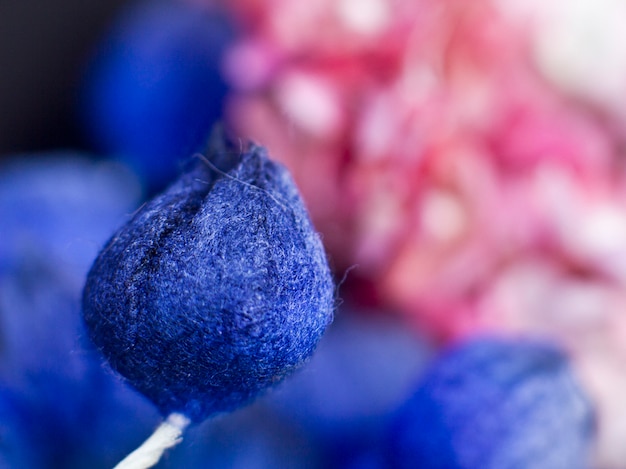 Bourgeons bleus et lilas roses sur fond noir. Fleurs artificielles