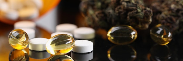 Bourgeons de marijuana sur ordonnance et capsule de pilule jaune et blanche
