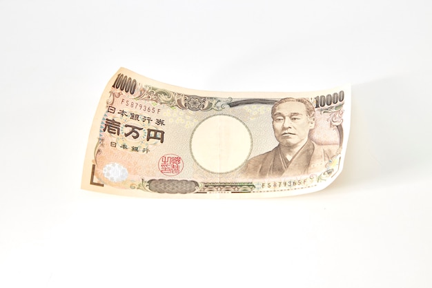 Boussole avec des billets de yen japonais et pièce de yen japonais sur fond blanc