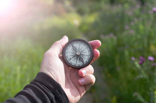 Photo une boussole dans une main dans la nature